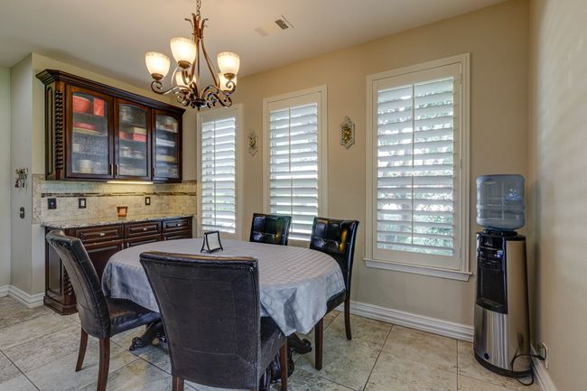Breakfast space with a chandelier, healthy amount of natural light, and light tile patterned floors | Image 15
