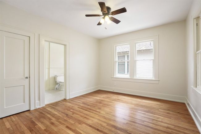 Unfurnished bedroom featuring light wood-type flooring, ensuite bathroom, and a ceiling fan | Image 20