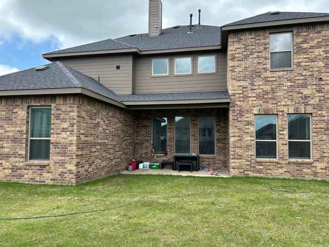 Rear view of property with a chimney, roof with shingles, a patio area, brick siding, and a yard | Image 9