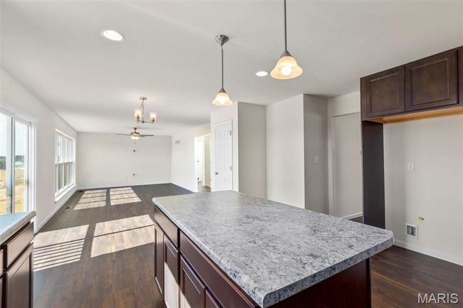 Kitchen with dark wood-type flooring, a chandelier, recessed lighting, decorative light fixtures, and open floor plan | Image 10