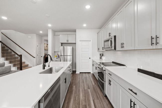 Kitchen with a sink, stainless steel appliances, light countertops, dark wood finished floors, and recessed lighting | Image 9