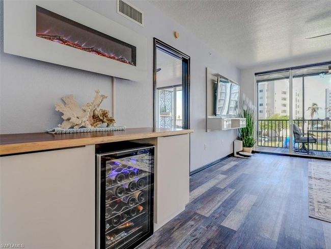 CUSTOM DINING AREA CABINETRY. BEVERAGE COOLER. WALL-MOUNTED ELECTRIC FIREPLACE. ENTRANCE TO OWNER'S SUITE IS SHOWN MIDDLE REAR. | Image 9