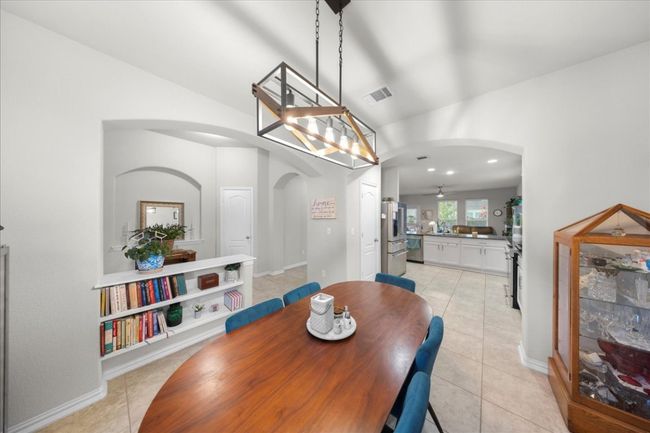 Dining area with arched walkways, light tile patterned floors, a ceiling fan, and vaulted ceiling | Image 4