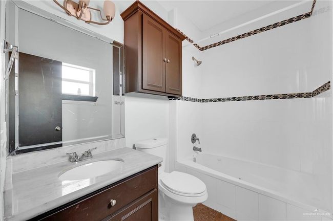 Spare room with a tray ceiling, baseboards, and ceiling fan | Image 6