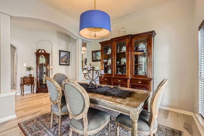 Dining room with arched walkways, light wood-style floors, and ornate columns | Image 7