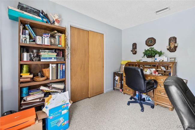 Carpeted office featuring a textured ceiling and visible vents | Image 19