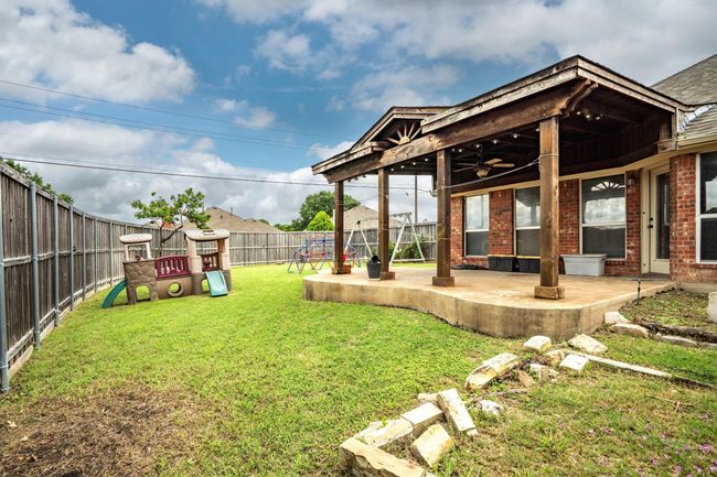 Fenced backyard with a playground and a patio | Image 37