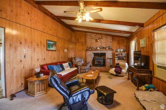 Carpeted living area featuring wood walls and a ceiling fan | Image 25