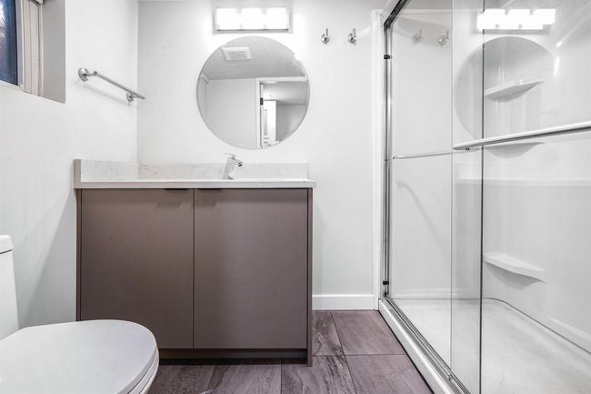 Bathroom featuring wood finished floors, toilet, a stall shower, and vanity | Image 17