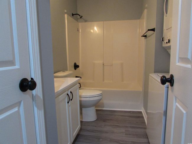 Bathroom with toilet, LVP flooring, vanity, and a shower / bath tub combination. | Image 15