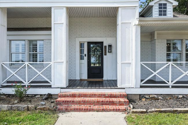 View of exterior entry featuring brick siding and covered porch | Image 6
