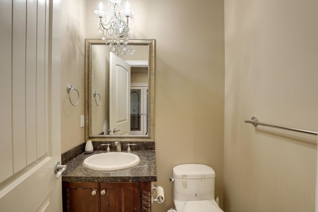 Bathroom with an inviting chandelier, vanity, and toilet | Image 25