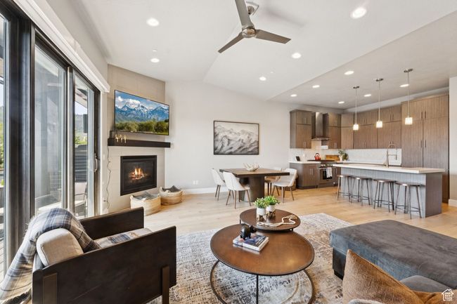 Living room featuring recessed lighting, a glass covered fireplace, light wood finished floors, vaulted ceiling, and a ceiling fan | Image 14
