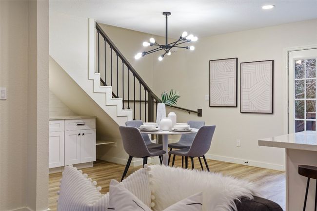 Dining space with baseboards, stairway, a notable chandelier, and light wood finished floors | Image 8