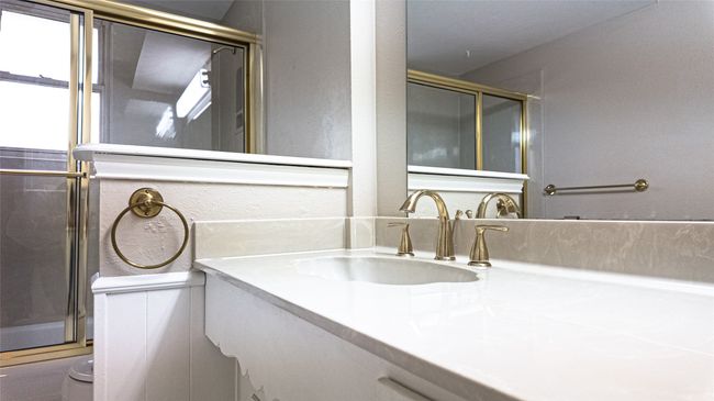 Bathroom with a textured wall, toilet, vanity, and a shower with shower door | Image 25