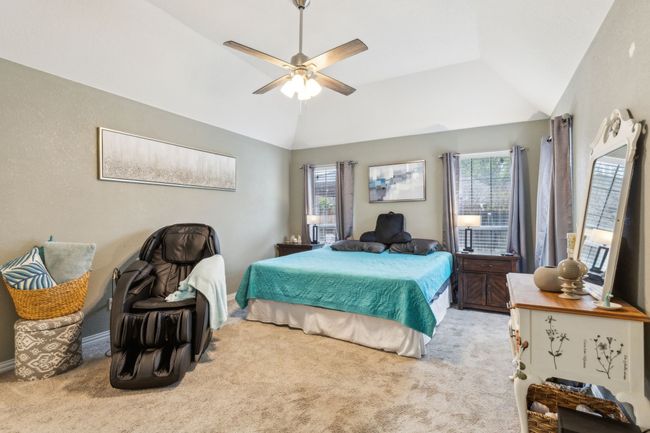 Carpeted bedroom featuring multiple windows, a ceiling fan, and lofted ceiling | Image 17