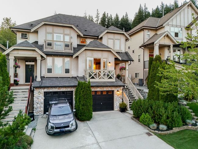View of front of house featuring stairs, covered porch, a balcony, and concrete driveway | Image 34