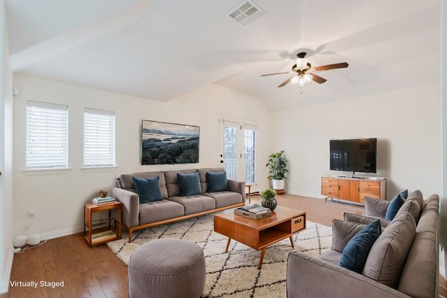 Upstairs Living area with visible vents, a ceiling fan, wood finished floors, baseboards, and lofted ceiling | Image 20