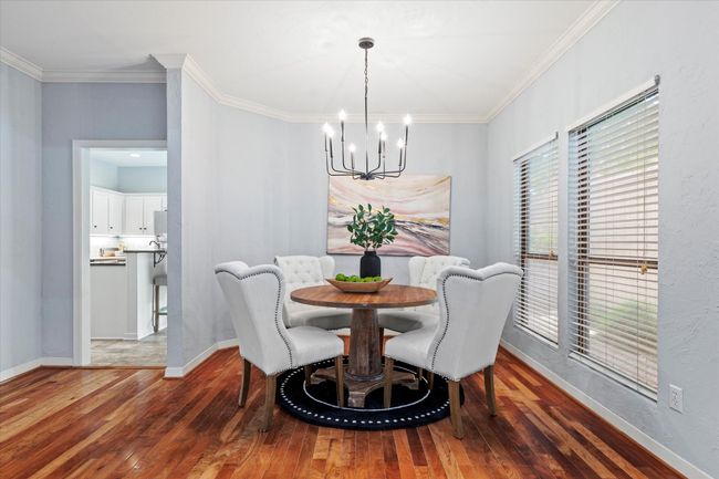 Dining space featuring a chandelier, hardwood / wood-style flooring, crown molding, and baseboards | Image 7
