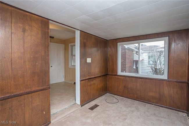 Empty room with wood walls and light colored carpet | Image 21