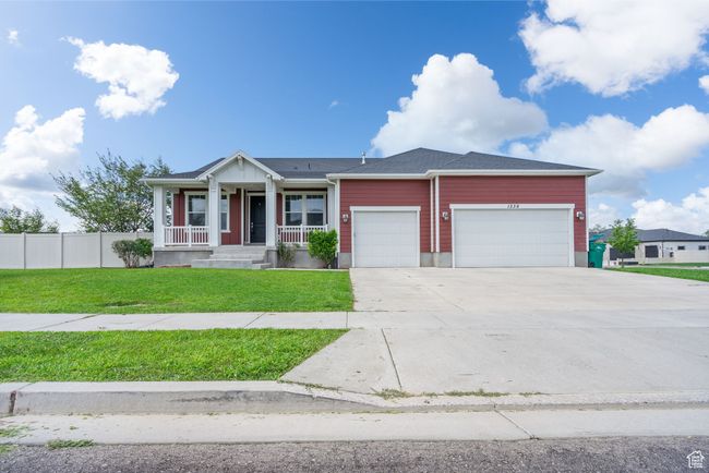 View of front of house featuring covered porch, a garage, and driveway | Image 44
