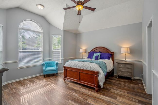 Stepping into the spacious primary suite, you’re greeted by gleaming floors, vaulted ceilings, and a charming bay window sitting area that invites relaxation. Chair railing adds a touch of elegance, while the generous layout offers plenty of room to unwind. | Image 17