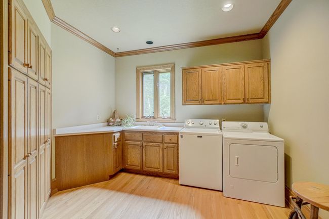 Every day chores are a breeze with this convenient main level laundry room with tons of cabinet space providing ample storage space | Image 34
