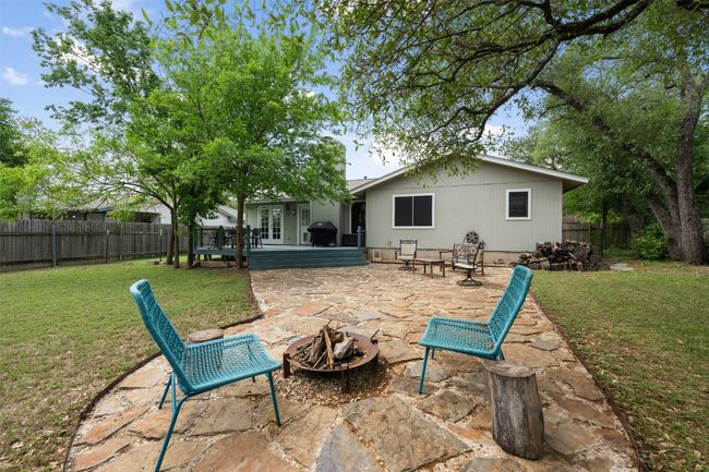 Back of house featuring a lawn, a fenced backyard, a fire pit, and a patio area | Image 27