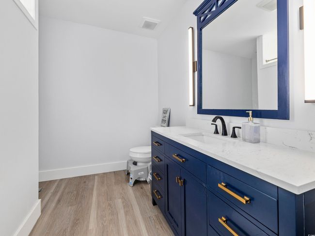 Bathroom featuring baseboards, vanity, toilet, and wood finished floors | Image 20