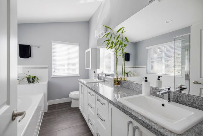 Full bathroom featuring double vanity, toilet, a bath, and a sink | Image 21