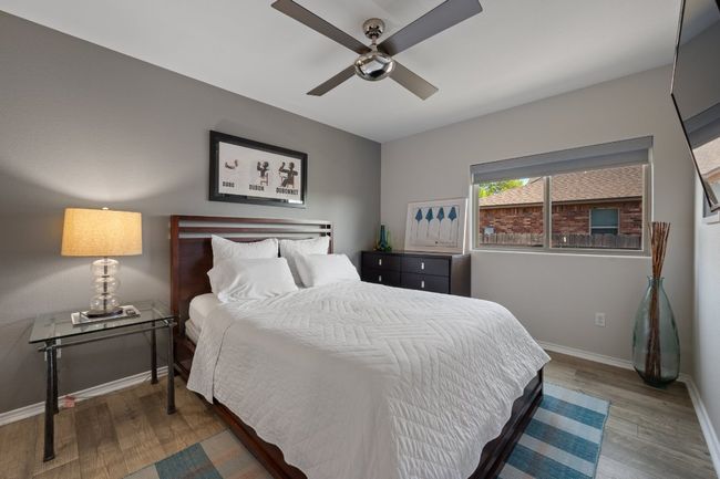 Bedroom featuring baseboards, a ceiling fan, and wood finished floors | Image 13
