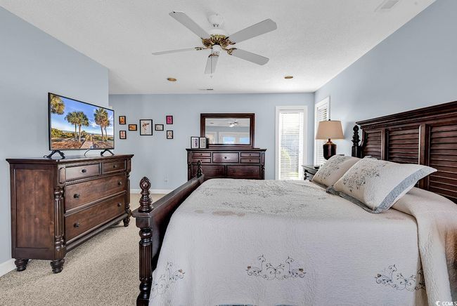 Bedroom with light carpet, baseboards, and ceiling fan | Image 19