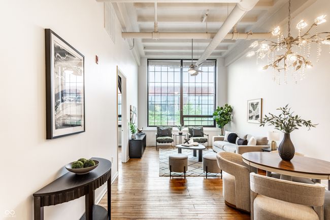 living area featuring beam ceiling, wood-type flooring, and a chandelier | Image 9