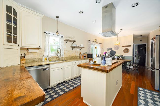 Kitchen with stainless steel appliances, butcher block countertops, a sink, plenty of natural light, and ornamental molding | Image 6