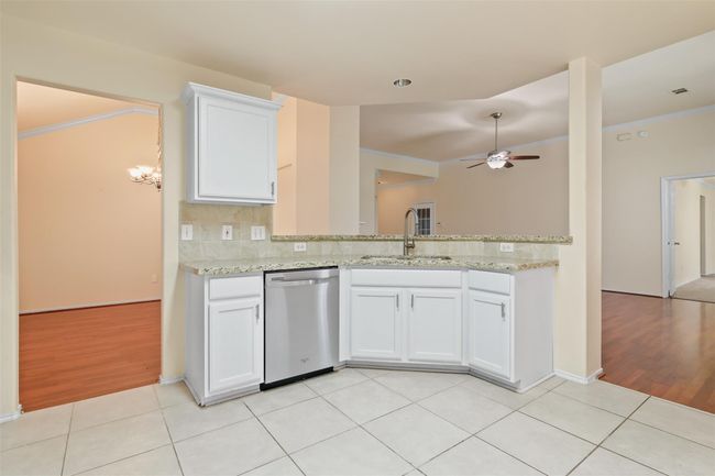 The kitchen has plenty of storage space, a breakfast bar and looks over into the family room. | Image 11