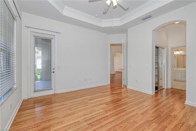 Spare room with crown molding, ceiling fan, a raised ceiling, and light hardwood / wood-style flooring | Image 33