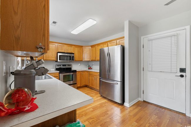 Kitchen with stainless steel appliances, light countertops, light wood-type flooring, and baseboards | Image 29