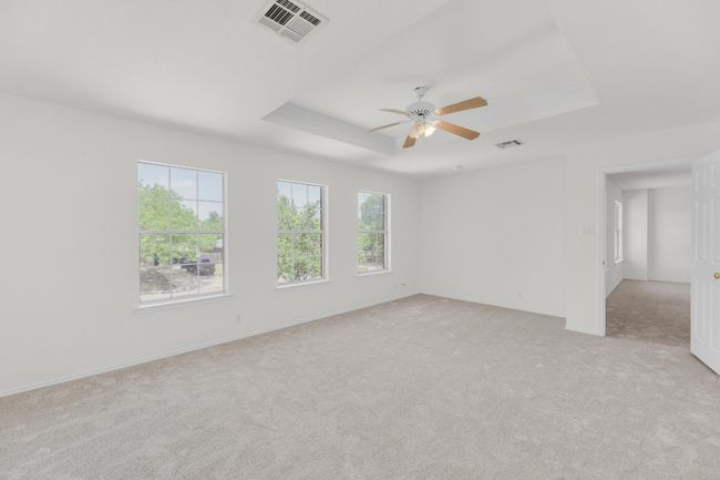 Unfurnished room with light carpet, a ceiling fan, visible vents, and a raised ceiling | Image 16