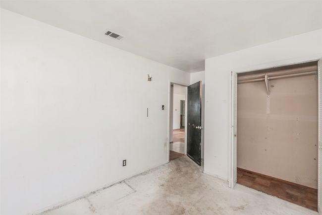 Unfurnished bedroom with a closet and concrete flooring | Image 30