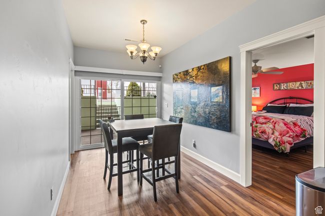 Dining area with hardwood / wood-style floors and ceiling fan with notable chandelier | Image 77