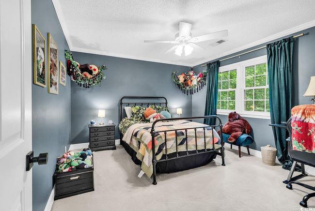 Carpeted bedroom with a textured ceiling, crown molding, and a ceiling fan | Image 21