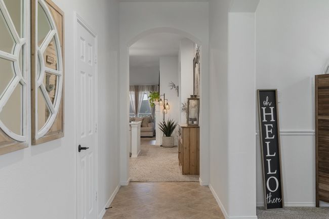 Hallway featuring arched walkways, light carpet, baseboards, and light tile patterned floors | Image 10