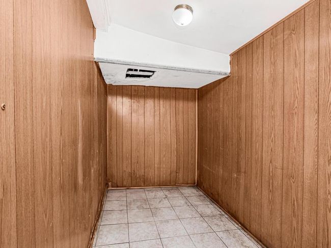 Unfurnished room featuring light tile patterned floors and wooden walls | Image 19
