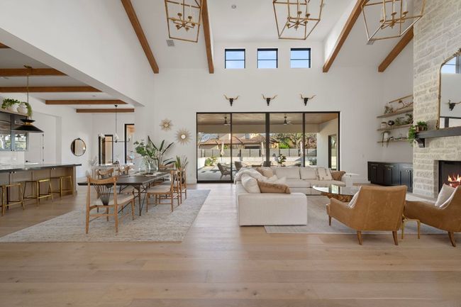 Living area with a fireplace, wood finished floors, and beam ceiling | Image 4
