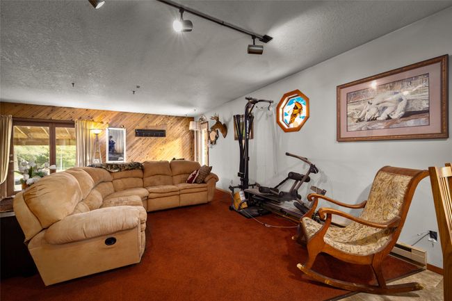 Living area with wooden walls, carpet floors, a textured ceiling, track lighting | Image 31