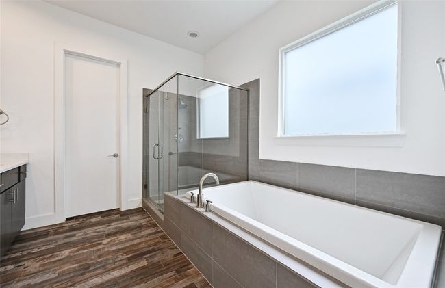 Bathroom with a garden tub, a shower stall, vanity, and wood finished floors | Image 15