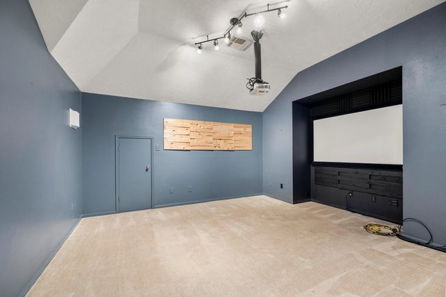 The dedicated media room is ready for movie marathons, complete with a projector setup and surround sound wiring. | Image 28
