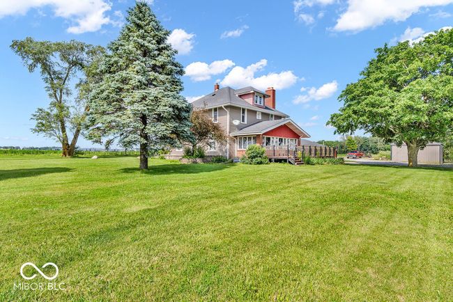 back of house featuring a deck, a yard, and a chimney | Image 4