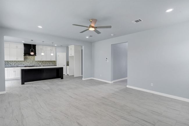 Unfurnished living room featuring a ceiling fan and recessed lighting | Image 10