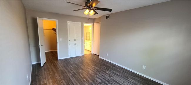 Unfurnished bedroom featuring dark wood finished floors, a closet, a spacious closet, and ceiling fan | Image 10